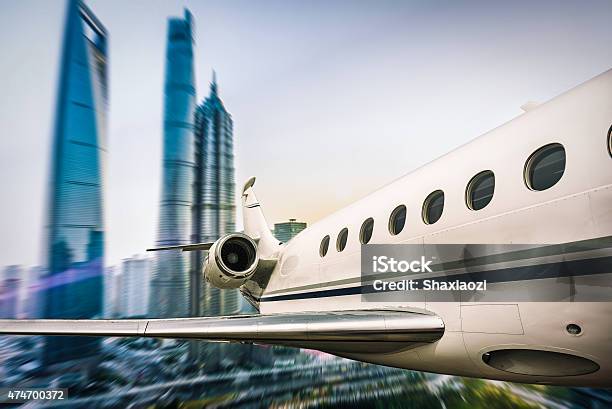 Flying Airplane Above City Stock Photo - Download Image Now - 2015, Above, Aircraft Wing