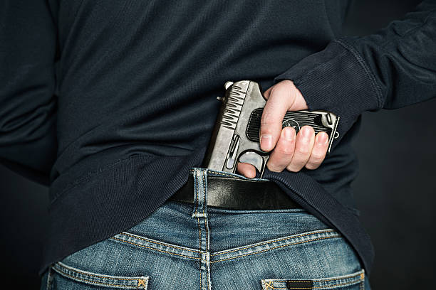 istock person is hiding a handgun under the denim belt. 474702468
