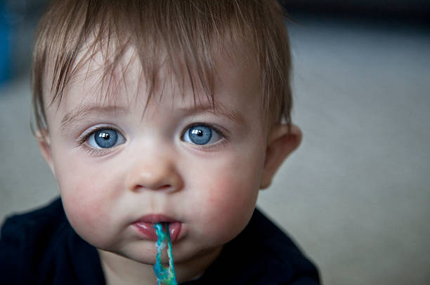 Portrait of a little baby with blue eyes Cute little teething baby, with red cheeks and blue eyes Teething Fever stock pictures, royalty-free photos & images