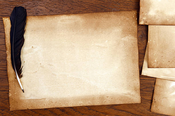 istock old paper with feather on brown wood texture 474705526