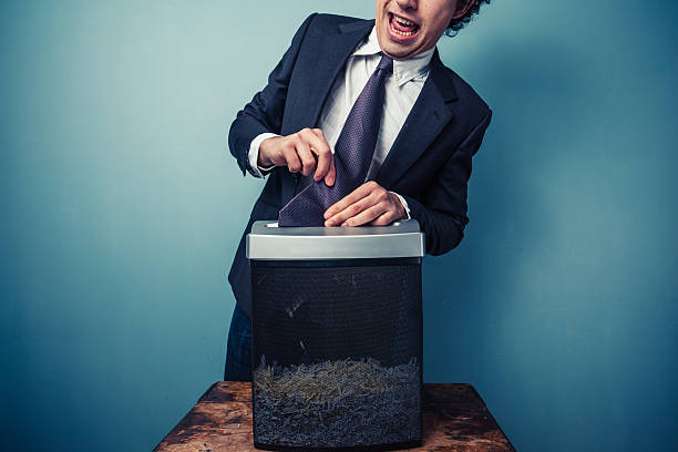 Clumsy businessman Clumsy businessman with his tie stuck in a paper shredder trapped fear people business stock pictures, royalty-free photos & images