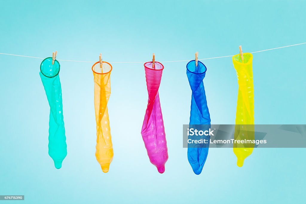 Colorful condoms Colorful and funny condoms hanging with clothspins on a rope. Condom Stock Photo