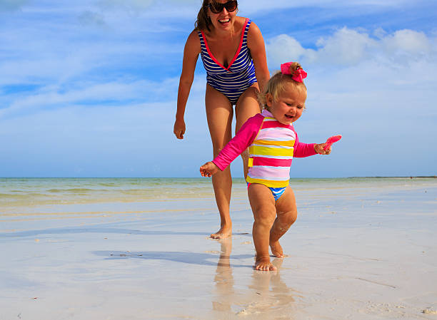 istock mother and little daughter having fun on the beach 474719814