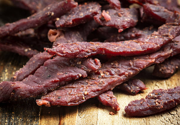 Beef Jerky on a cutting board Beef Jerky on a cutting board chewy photos stock pictures, royalty-free photos & images
