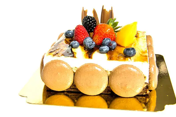 tiramisu cake with top freshfruit isolated on white.
