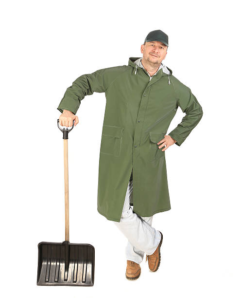 istock Man in long vest with shovel 474723855