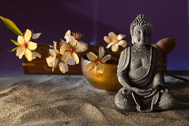 istock stone sitting buddha flowers and  Tibetan bowl 474724352