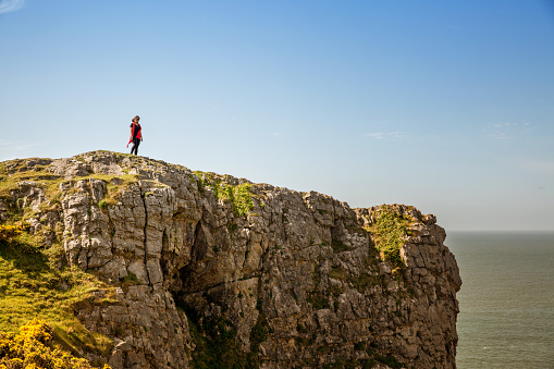 Mature hispanic woman standing on remote coastal headland