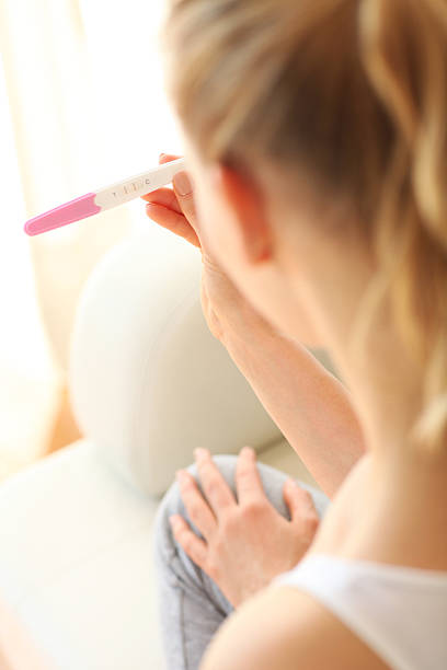 istock Young woman looking on pregnancy test 474730074