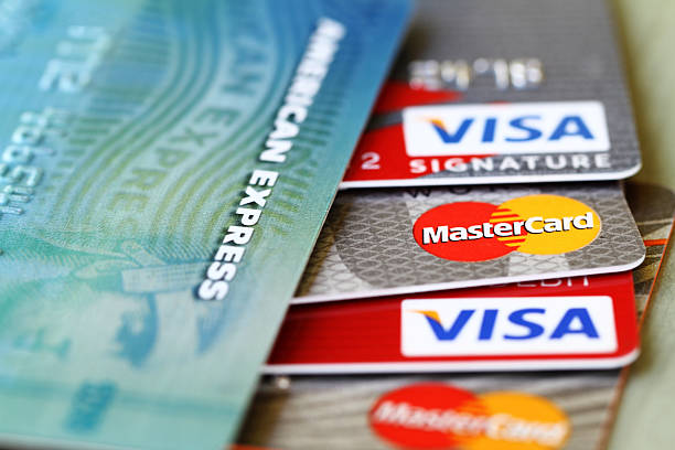 Major credit cards: Visa, Master Card and American Express West Palm Beach, USA - May 19, 2015: Partial view of major credit cards: VISA, Master Card, and American Express. Extreme closeup with selective focus and very narrow depth of field. american express stock pictures, royalty-free photos & images