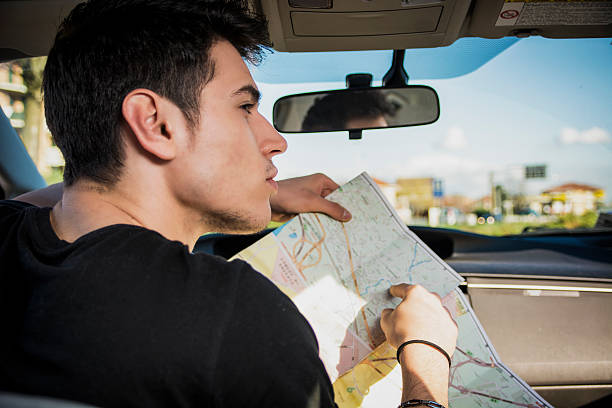 istock Gorgeous Young Man Inside Car Asking for Directions Holding a 474740908