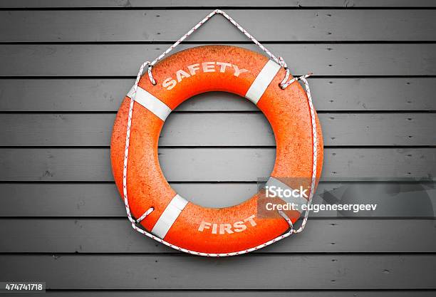 Safety First Red Lifebuoy Hanging On Gray Wall Stock Photo - Download Image Now - Buoy, Salvation, 2015