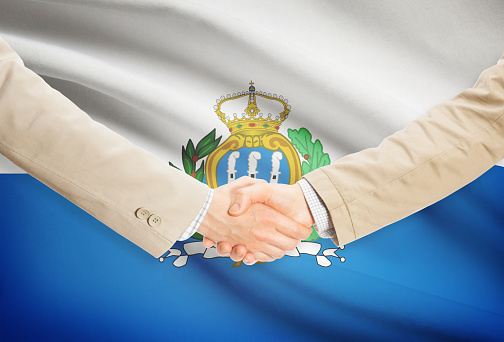 Businessmen shaking hands with flag on background - San Marino