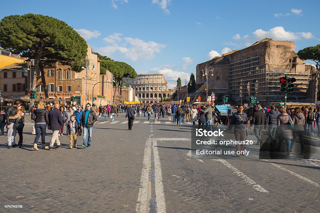 The road to colesseum in Rome, Italy. Rome, Italy - April 6, 2015: The crowd of people are hanging out on the road to colosseum in Rome, Italy. 2015 Stock Photo