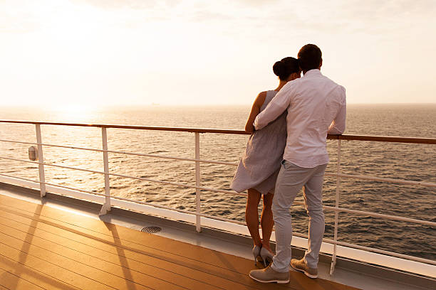 joven pareja abrazándos'en crucero al atardecer - crucero fotografías e imágenes de stock