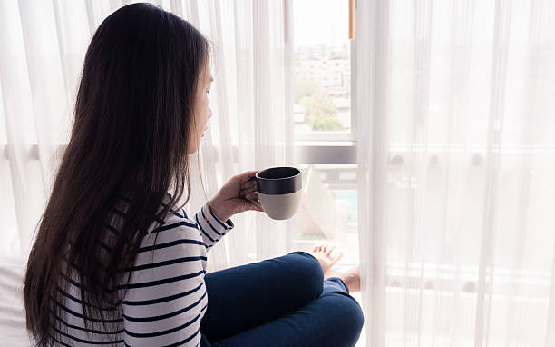 istock female hands holding coffeecup on bed 474749626