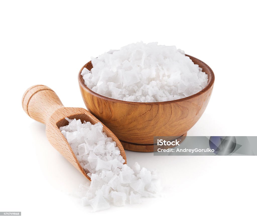 Cyprus sea salt flakes in a wooden bowl Cyprus sea salt flakes in a wooden bowl isolated on white background Salt - Mineral Stock Photo