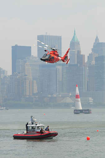 New York City, USA - June 20, 2010: US Coast Guard Helicopter hovering above  US Coast Guard boat with crew members as part of a demonstration to the public and spectators, as part of the Red Bull Air-Race worldwide series of competitions. Images were taken during the 2010 season from the NJ city coast side of the Hudson river.