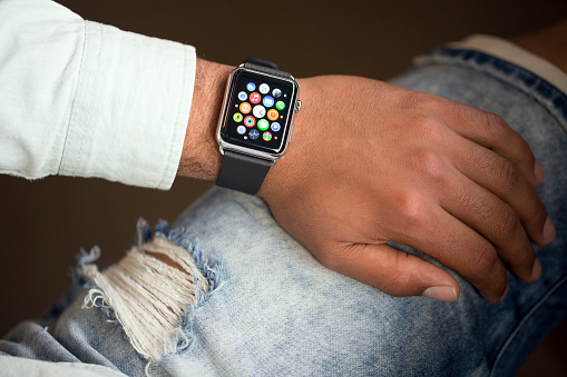 Izmir, Turkey - May 21, 2015: A man wearing 42mm stainless steel Apple Watch with classic black buckle. The Apple Watch became available April 24, 2015, bringing a new way to receive information at a glance, using apps designed specifically for the wrist.