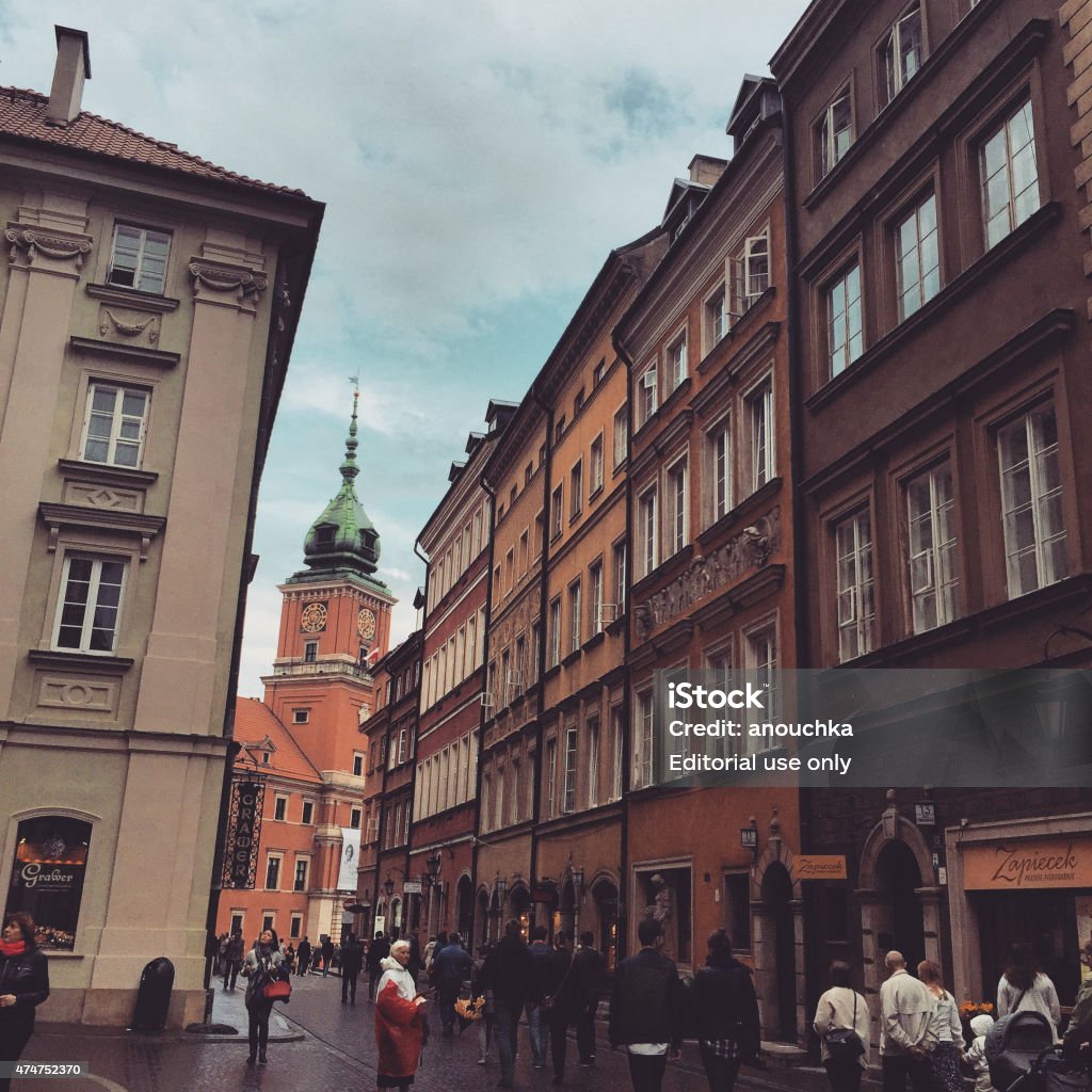Warsaw old town streets Warsaw, Poland - April 26, 2015: Warsaw old town: Castle Square visible ahead, tourists walking around on a rainy day.  2015 Stock Photo