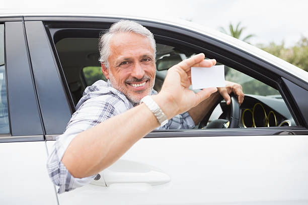istock Man smiling and holding card 474752728