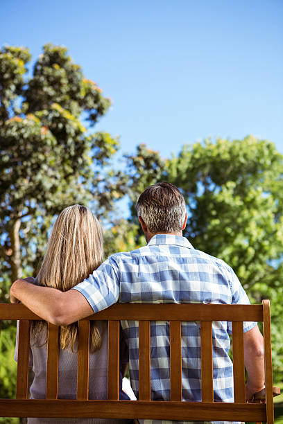 istock Couple relaxing in the park on bench 474753644