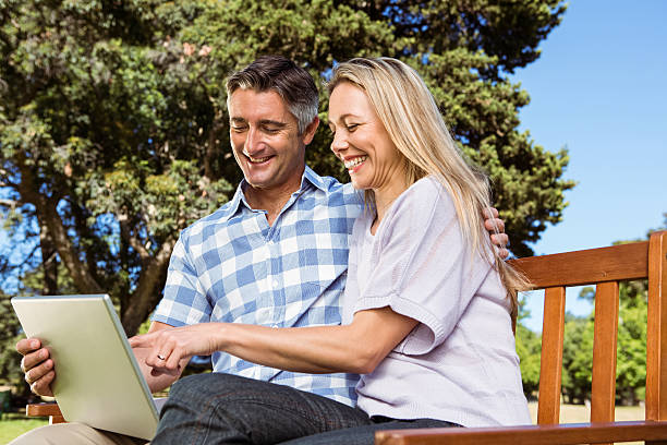 istock Couple relaxing in the park with laptop 474753758