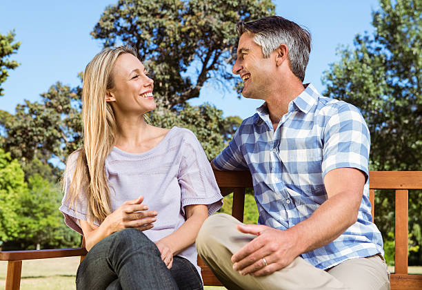 istock Couple relaxing in the park on bench 474753782
