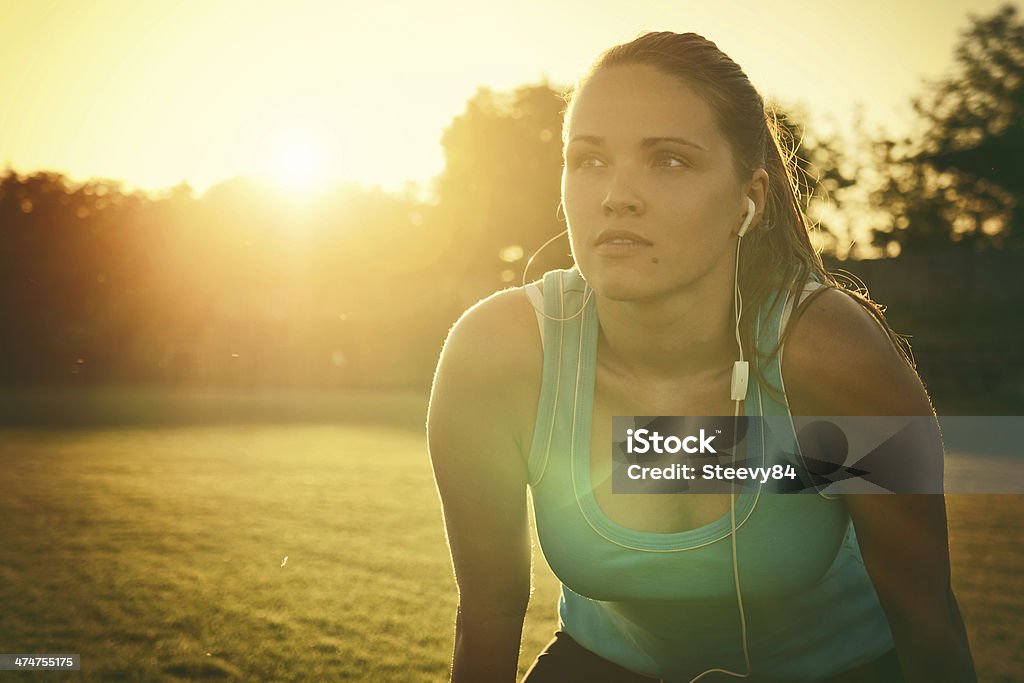 Sporting in the sunset Vintage style photo from a young woman is tired after run Exercising Stock Photo