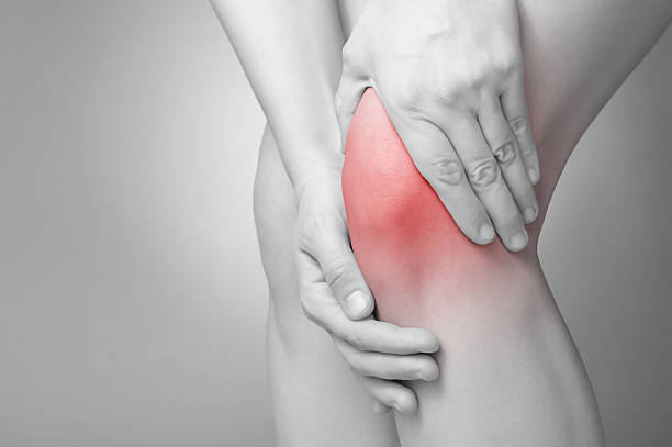 Knee pain A young woman massaging her painful knee human knee stock pictures, royalty-free photos & images