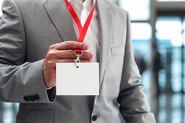 Photo of Businessman holding blank ID badge