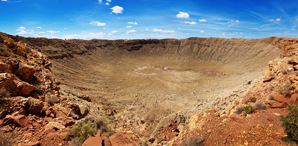 A panoramic view of The Barringer Crater, the meteorite impact crater in Arizona in the southwest USA. One of the best preserved meteor crater in the world, the Barringer Crater, a national landmark in the USA is some 570 feet or 170 meter deep, 3900 feet or 1200 meter diameter. Photographed in a panoramic horizontal format.