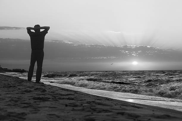 istock Monochrome image of man at sunrise on beach 474768828