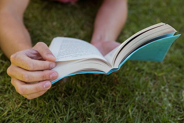 istock Pretty woman reading book in park 474769120