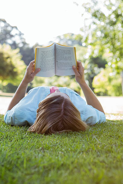 istock Pretty woman reading book in park 474769886