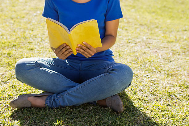 istock Woman reading book in park 474771644