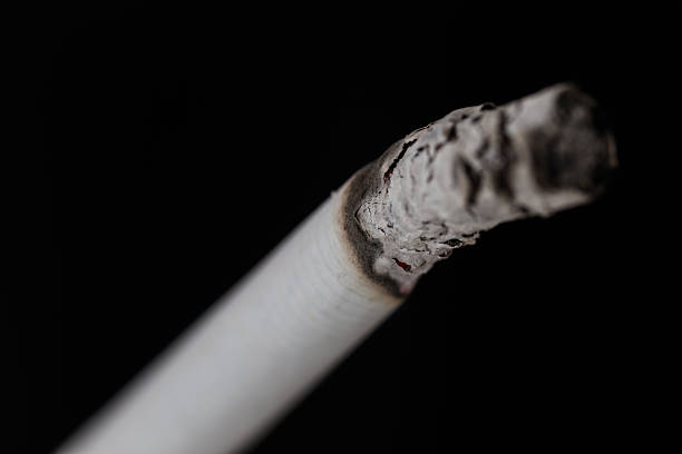 istock Burning cigarette with smoke on black background 474771744