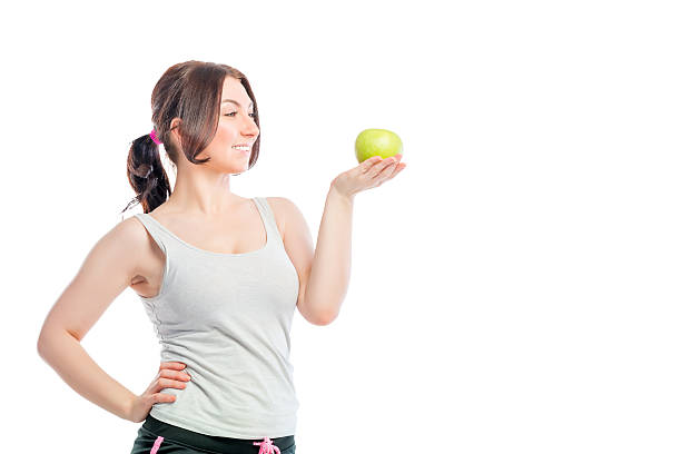 istock happy girl on a diet looking at apple 474781872