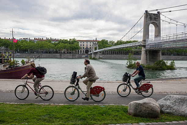 tre adulti in bicicletta a lione, francia - rhone bridge foto e immagini stock