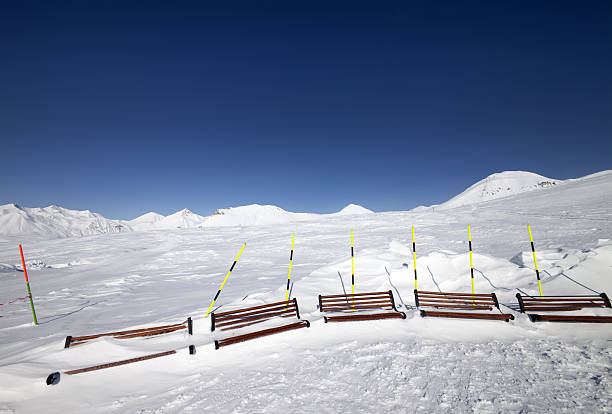 istock Ski slope and wooden benches in snow 474790312