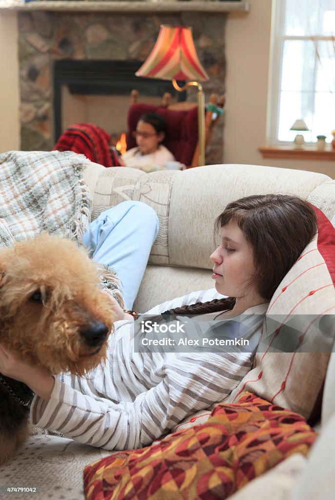 Two sisters, teenager girls, playing with tablet and smartphone Two sisters, teenager girls, playing with tablet and smartphone in the living room on the couch. 14-15 Years Stock Photo