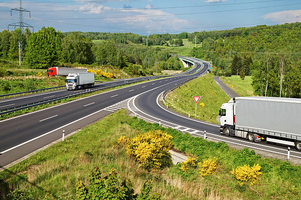 istock Highway in the countryside. Three moving trucks. 474799120