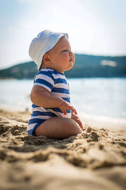 istock Little baby boy sitting on the sand 474803492