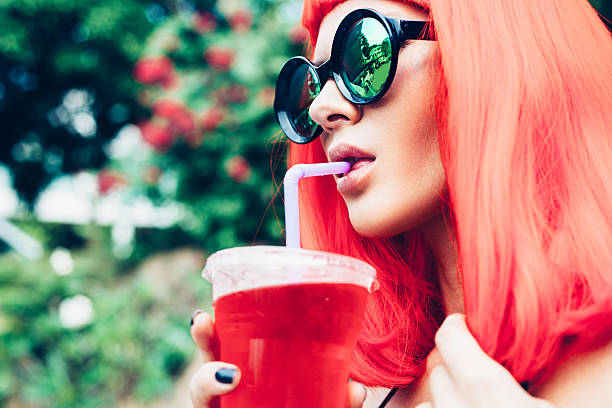 istock Woman in red wig and black bikini drinking cocktail 474804072