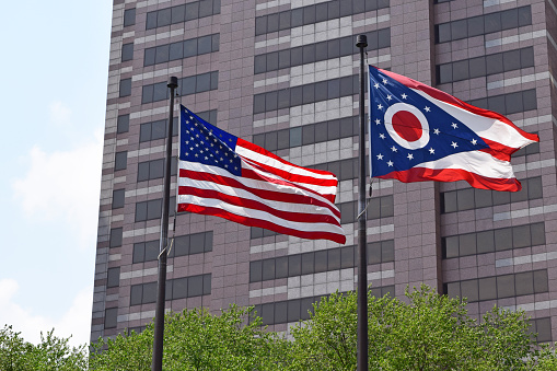 Downtown Columbus Ohio on a beautiful spring day with the Ohio and USA flags blowing in the wind. Columbus is the capital of Ohio and largest city of Franklin County.