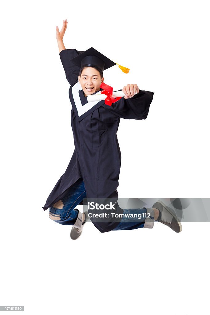 Happy  student in graduate robe jumping against white background Graduation Stock Photo
