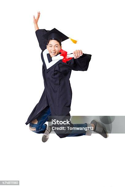 Happy Student In Graduate Robe Jumping Against White Background Stock Photo - Download Image Now