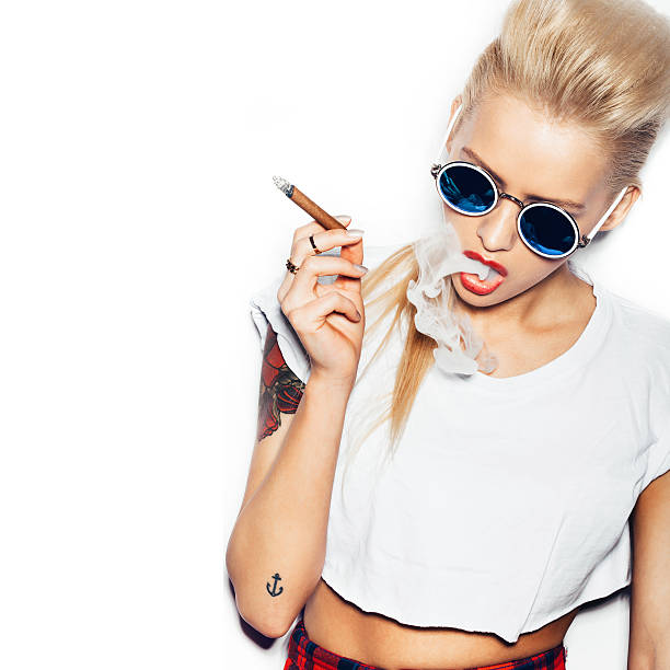 Sexy blonde woman in sunglasses smoking cigar stock photo