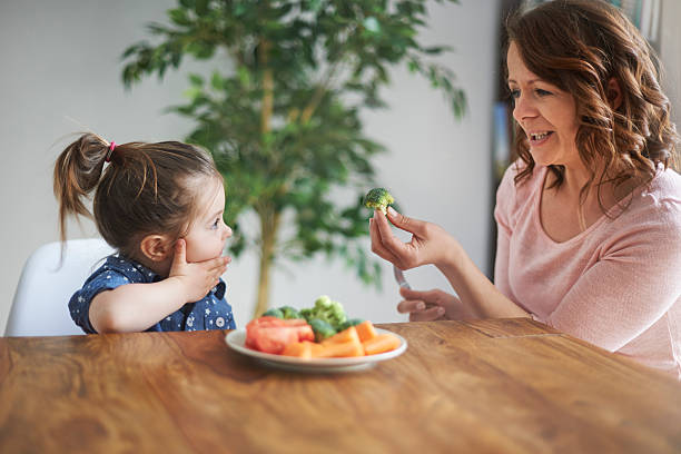 nie lubię z brokułów! - baby eating child mother zdjęcia i obrazy z banku zdjęć