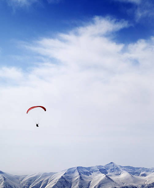 Parachutist silhouette of mountains at windy sky. Caucasus Mountains. Georgia, ski resort Gudauri.